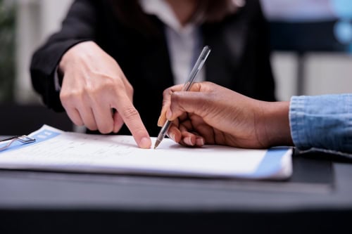 Imagine of a businessperson directing a customer where to sign