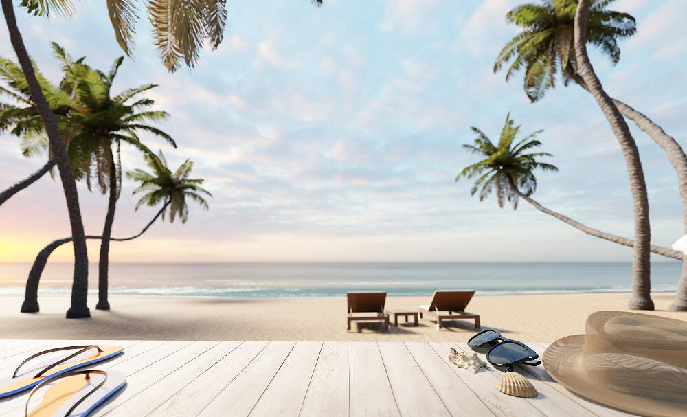 A sandy Bahamas beach with two lounge chairs facing the ocean, surrounded by palm trees, as seen from a wooden deck in Albany. Sunglasses, a hat, and seashells rest in the foreground—perfect for relaxing or discovering premier real estate.