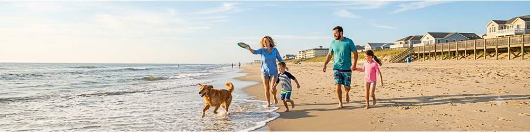 Family playing with golden retriever on dog-friendly Delaware beach, summer 2026