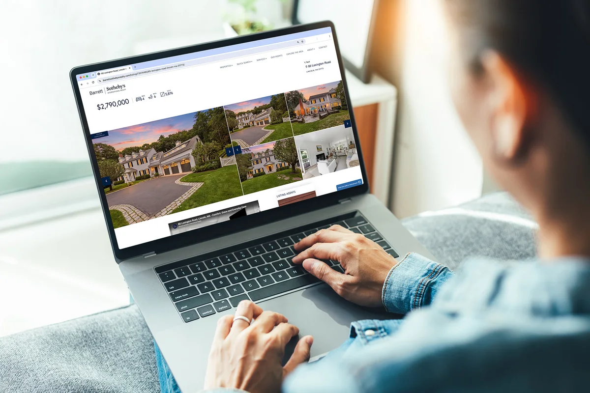 Browsing a Barrett Sotheby's International Realty listing on a laptop