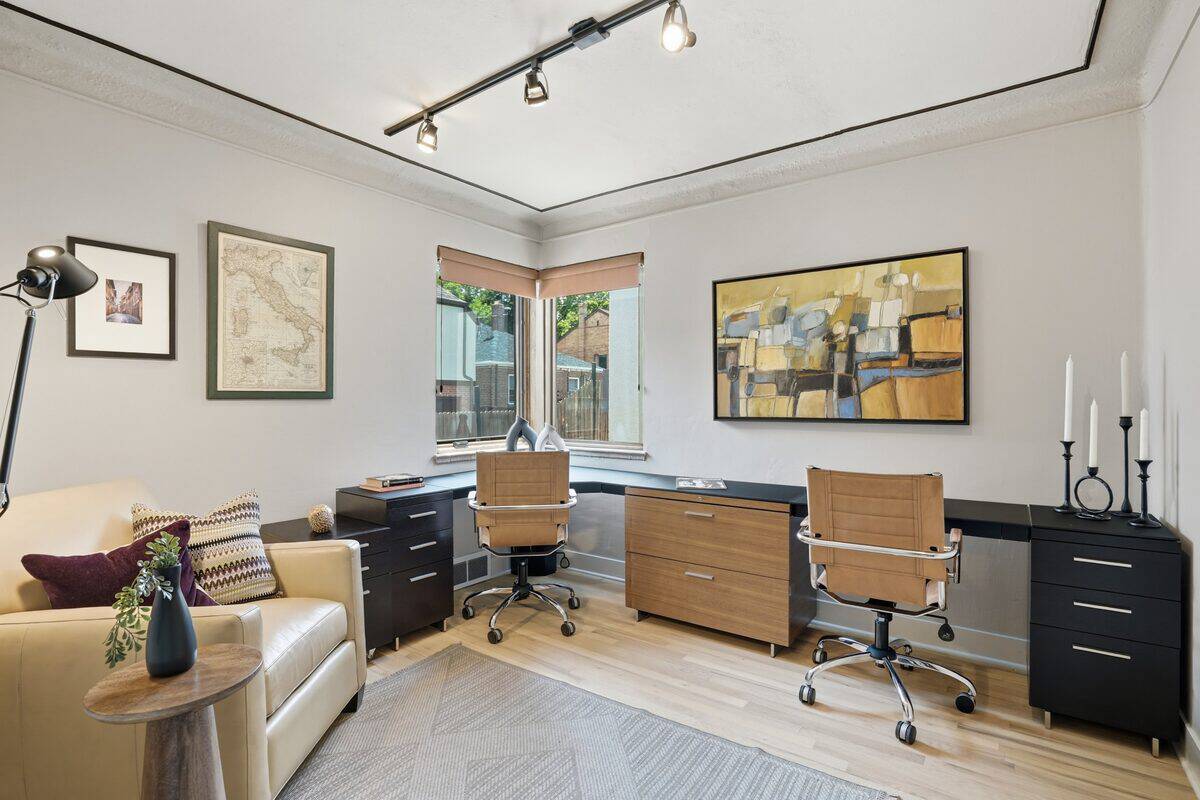 Home office with light walls, an L-shaped desk, two chairs, and a loveseat after staging, Denver