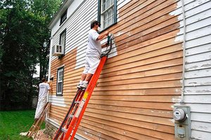 Scraping old paint from a home's exterior