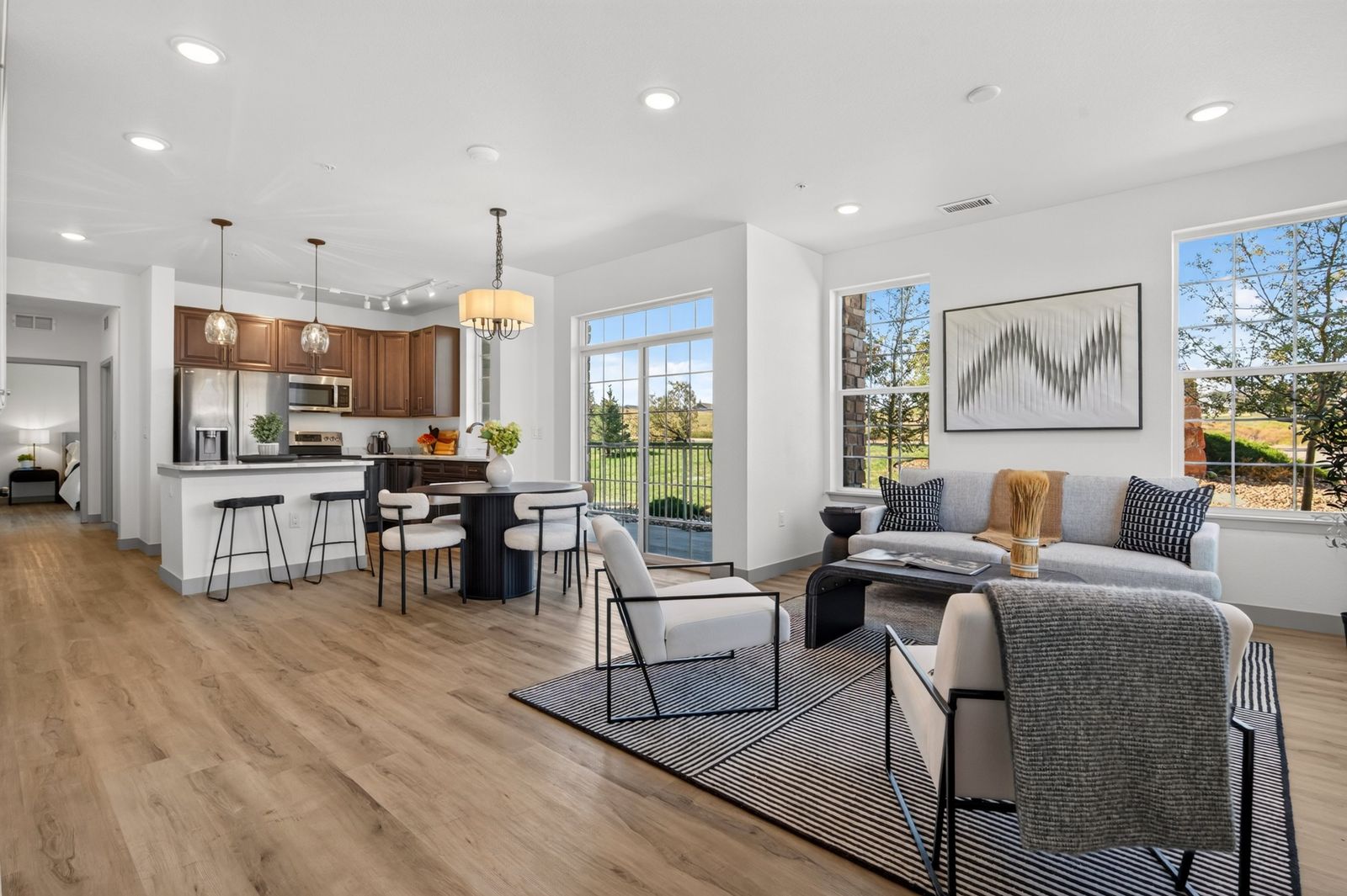 Open kitchen, dining and living room with luxury vinyl plank floors in a Hunters Chase condo in Parker, CO
