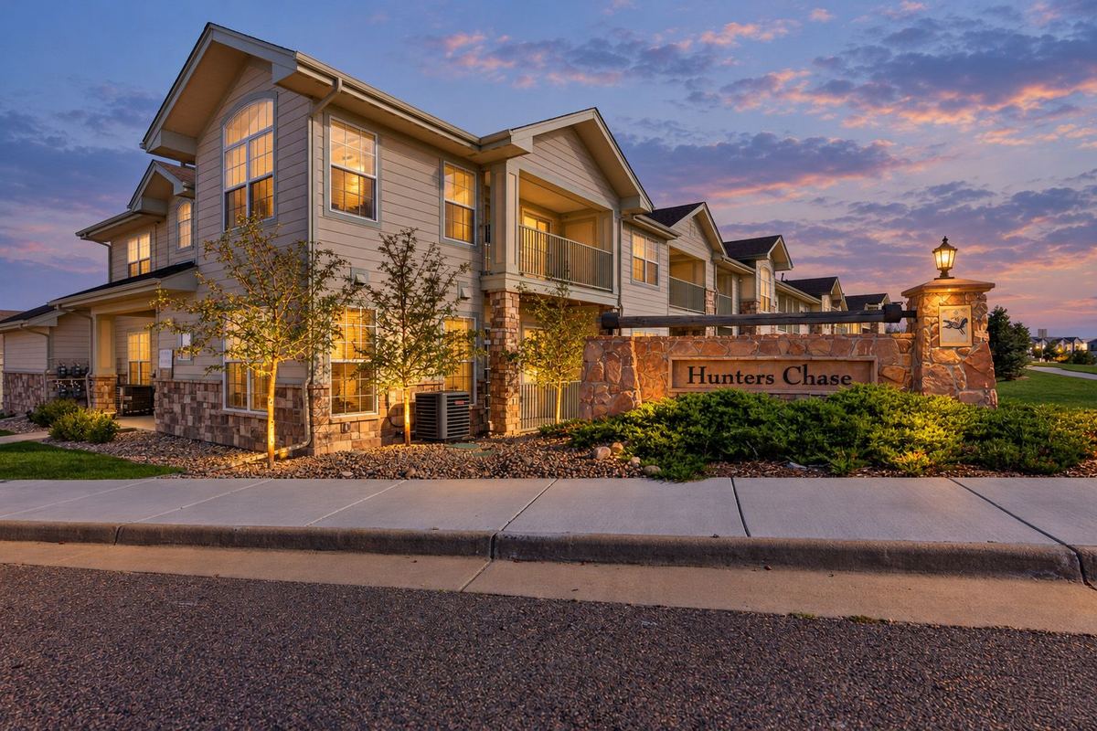 Hunters Chase entrance sign and condominium building at dusk in Parker, CO