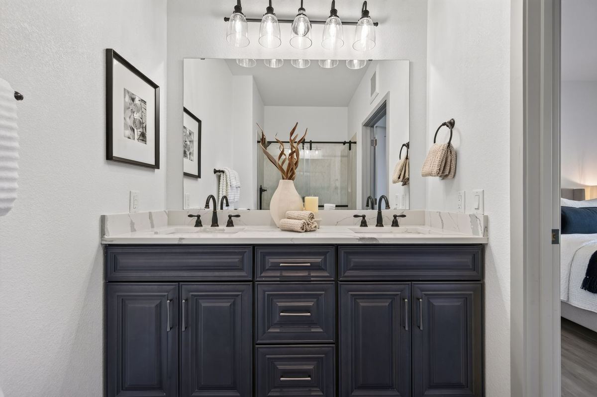 Bathroom with a double vanity, navy cabinets and quartz counters at Hunters Chase