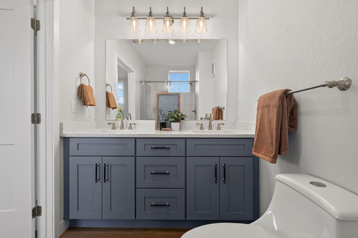Double vanity bathroom with blue cabinets at Hunters Chase
