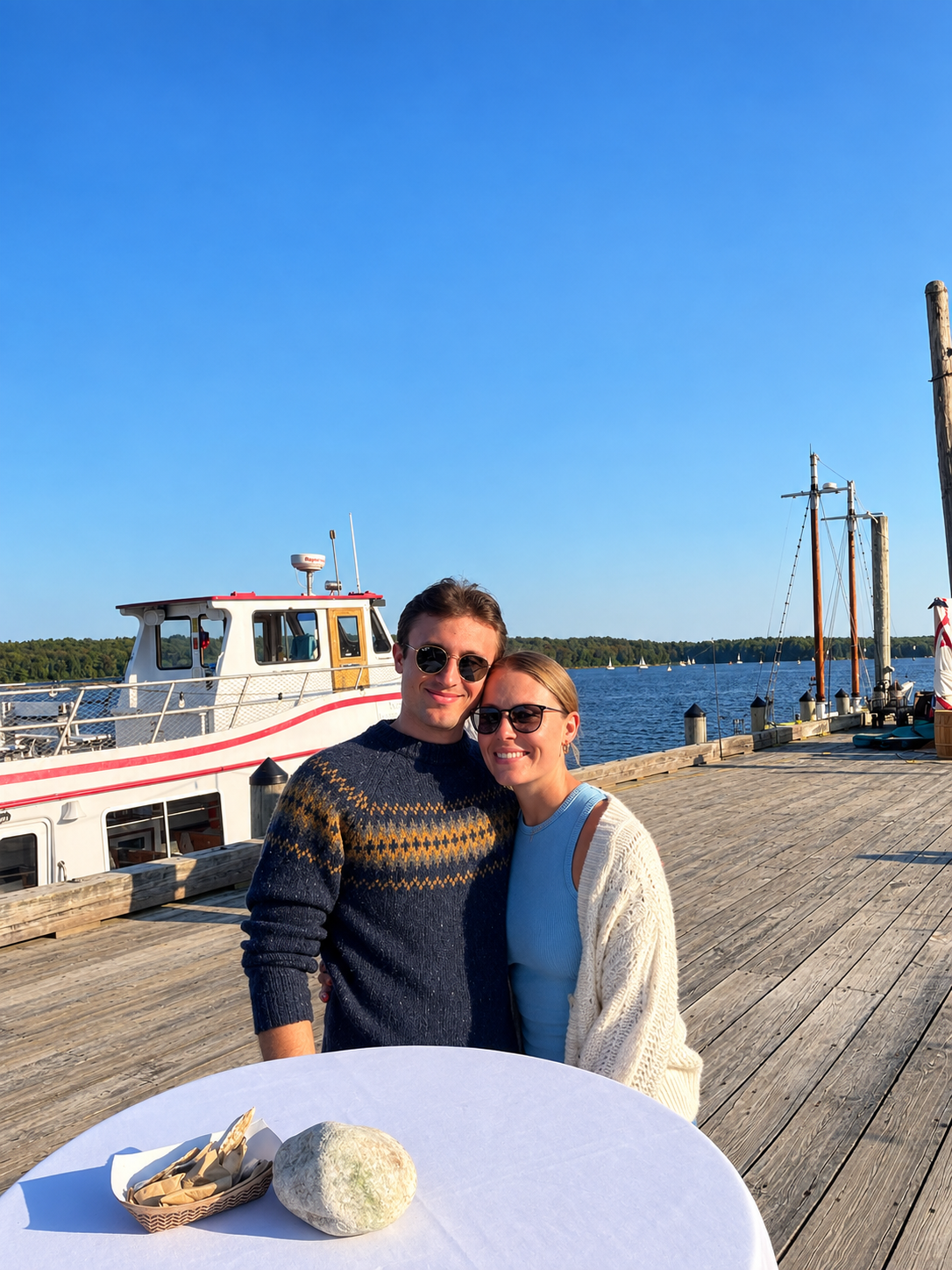 Alexis Franco and her fiancé, Tyler, on a sunny wharf beside a docked boat