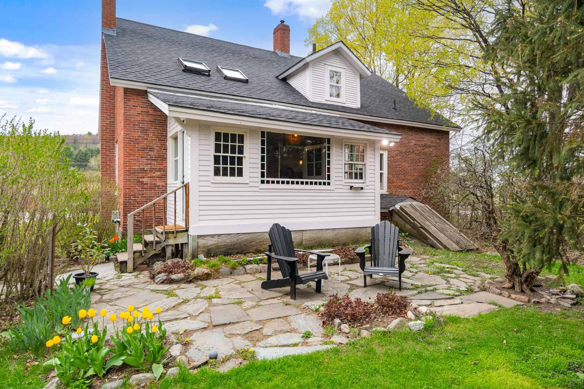 A charming Vermont home with manicured landscaping, blooming late-summer flowers.